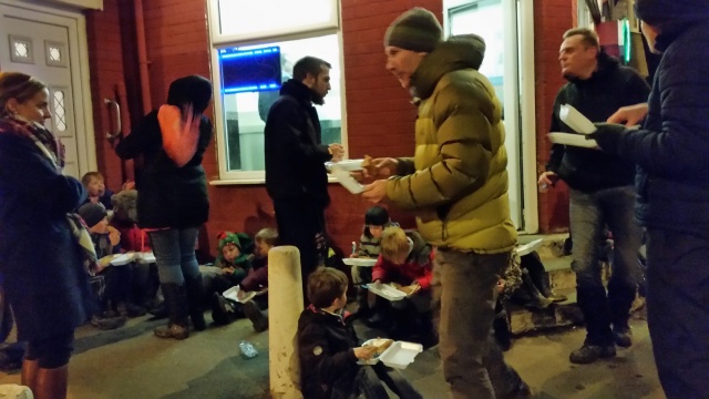 The beaver scouts and adults are having boxed meals on the street.