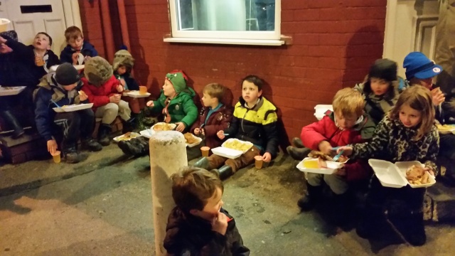 The beaver scouts and adults are having boxed meals on the street.