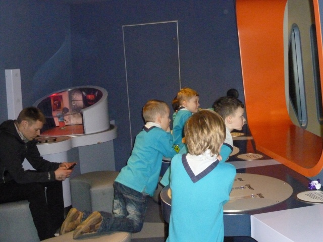 Four beaver scouts are looking at something carefully.